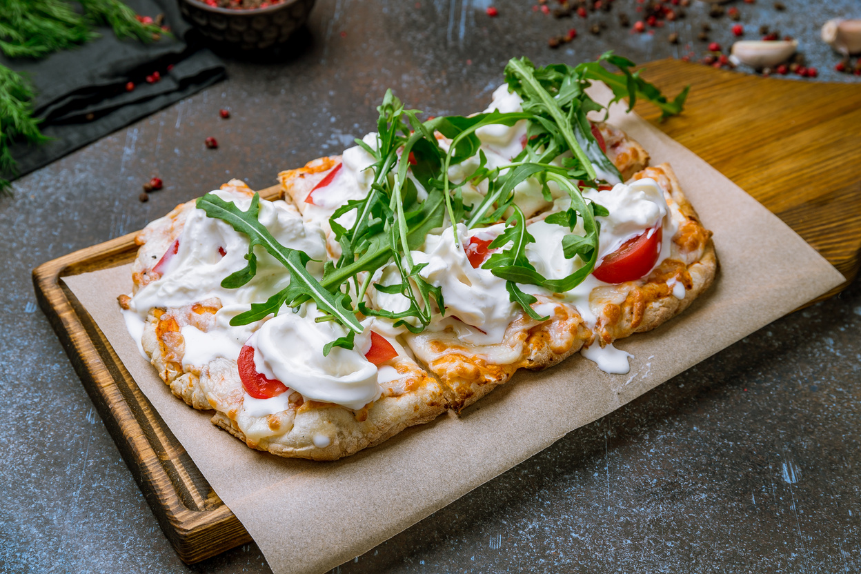 Pinsa with tomatoes, aragula and stracciatella. rome pizza